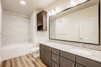 A bathroom with a marble patterned wall and a white toilet.